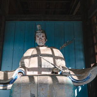 古殿八幡神社の境内に鎮座する像に落ちる格子の影の写真
