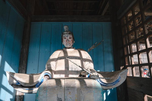 古殿八幡神社の境内に鎮座する像に落ちる格子の影