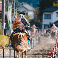 古殿八幡神社例大祭の流鏑馬コースを疾走する装束姿の射手の写真