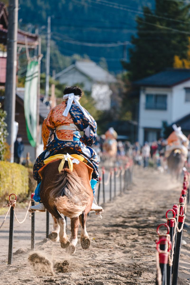古殿八幡神社の例大祭で流鏑馬コースを疾走する装束姿の射手と馬