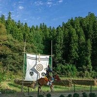 古殿町の稲架掛け背景に流鏑馬で的に命中させた瞬間の写真