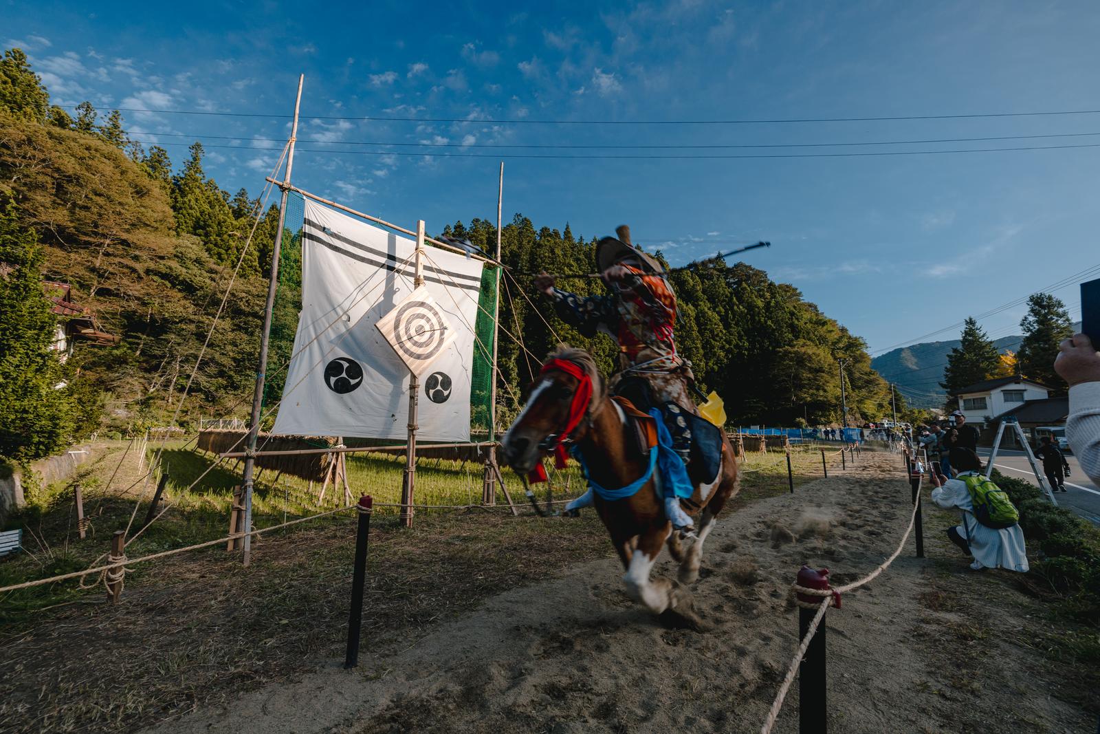 古殿町の流鏑馬大会で、馬に乗った射手が的に向かって疾走する様子