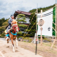 流鏑馬の第三の的を狙い疾走する騎手と馬、古殿八幡神社の写真