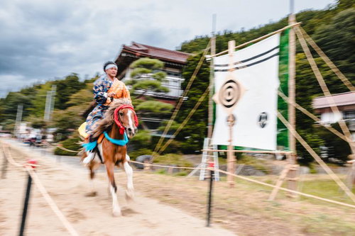 流鏑馬の第三の的を狙い疾走する騎手と馬、古殿八幡神社