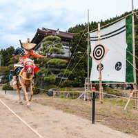 古殿町の古殿八幡神社で行われる流鏑馬、走り抜ける馬と的を射抜く射手の写真