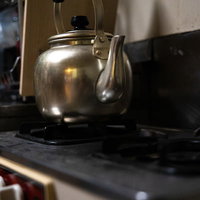 ガス台に置かれた光沢のあるやかんの写真
