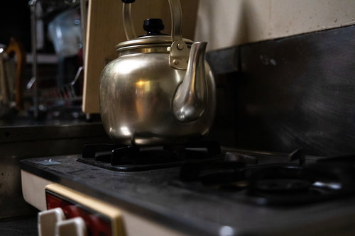 ガス台に置かれた光沢のあるやかん