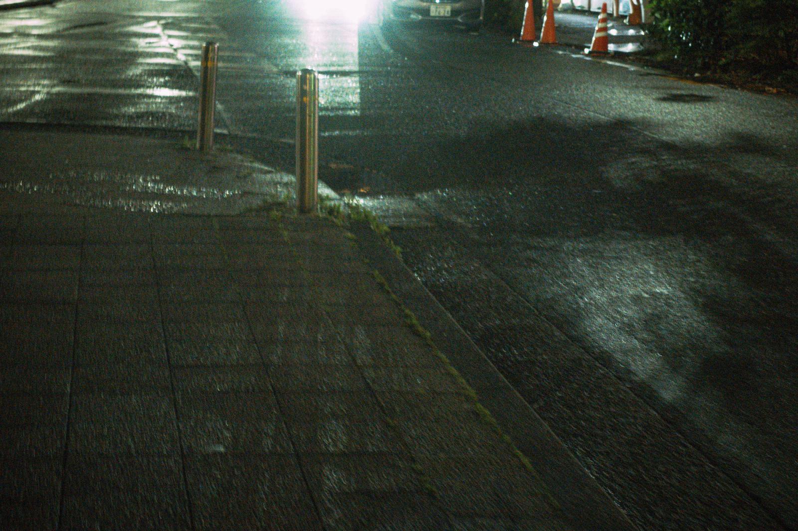 夜間の都市道路の歩道と工事標識が見える夜景写真