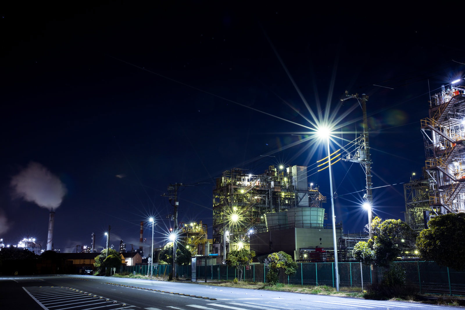 千鳥町1号線の夜景、街灯の光芒と背景の工場夜景が写る道路