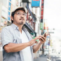 お店の場所がなかなか見つからない男性（迷子クラスタ）の写真