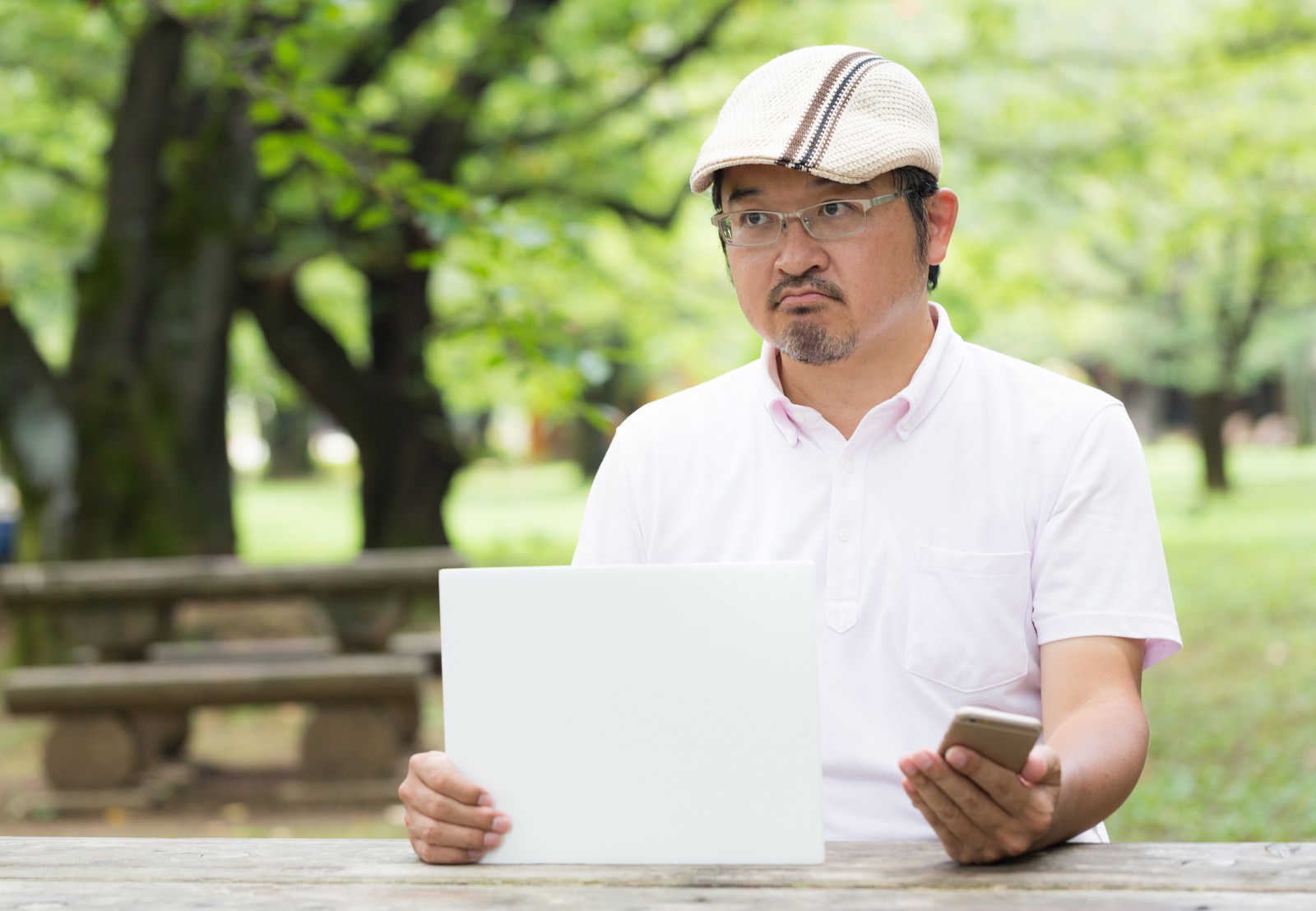 スマホを持ち手を突き出して怒る中年男性［モデル：ナリシゲ］