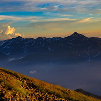オレンジに染まり始める立山連峰と剱岳の山峰の写真