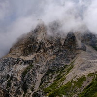 沸き立つガスに包まれた白馬岳の岩山の登山道の写真