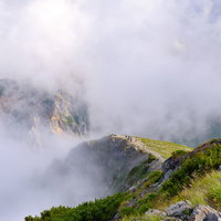 ガスに隠れた杓子岳と切れ間からあらわれる登山道の写真