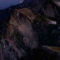夕暮れ時にピンク色に染まる白馬連峰の山峰の写真