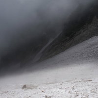 ガスに包まれた厳しい悪天候の白馬大雪渓での登山者の歩み（白馬岳）の写真