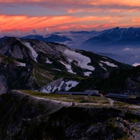 夕日に染まる杓子岳と白馬鑓ヶ岳、立山連峰の山並みの写真