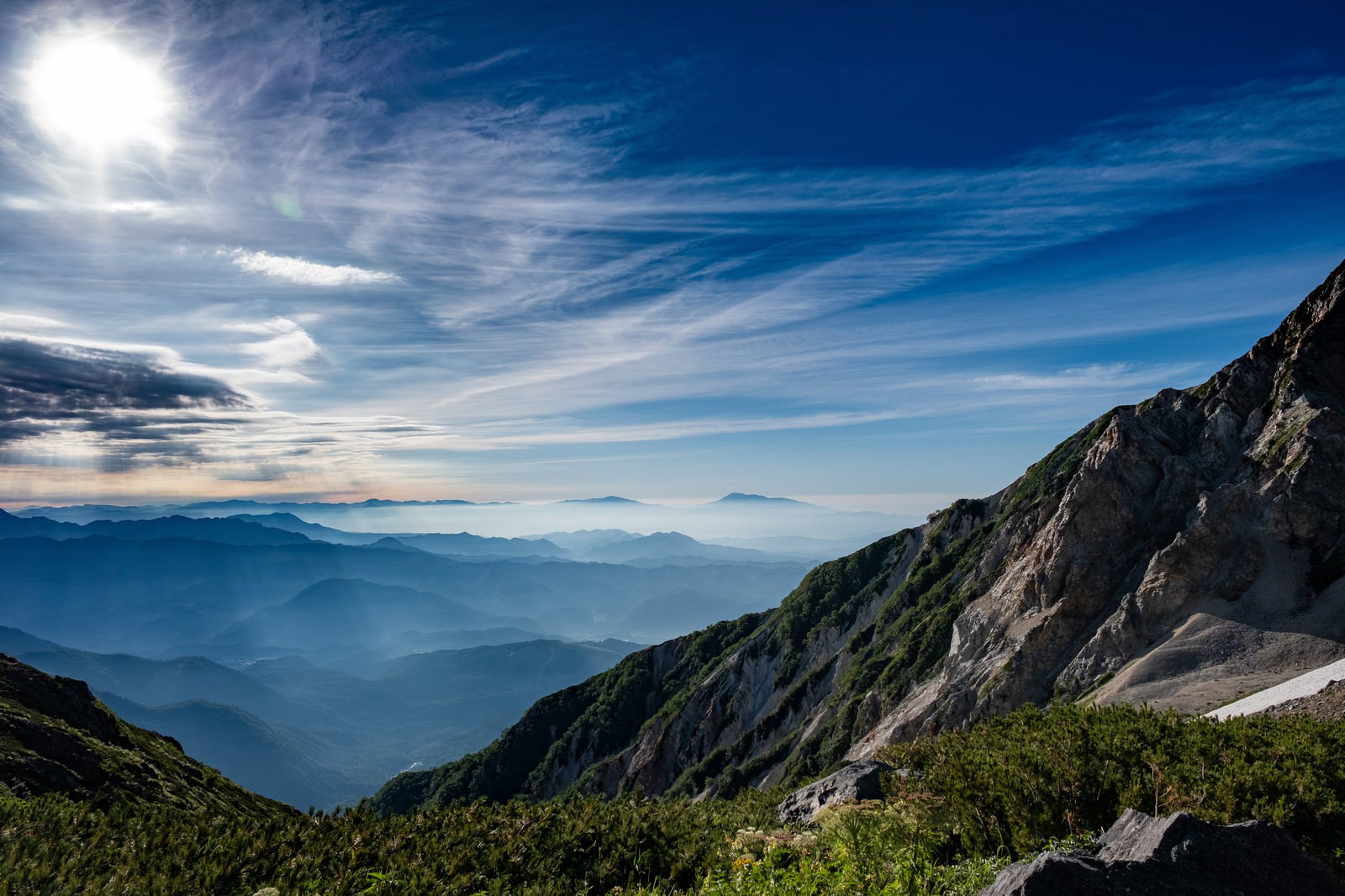 霞と光芒を俯瞰した山岳風景、青空と連なる山々の稜線