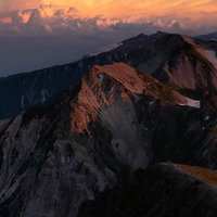 日没間近の白馬連峰と北アルプスの山稜線の写真