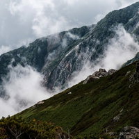 朝霧が立つ白馬連峰の稜線と登山者の写真