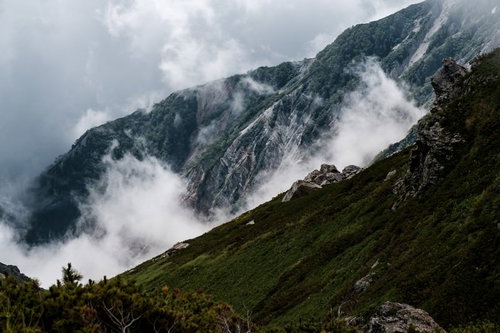 朝霧が立つ白馬連峰の稜線と登山者