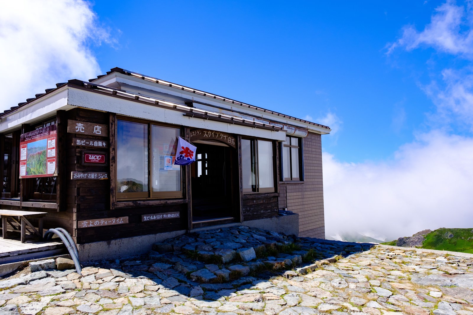 白馬岳の山稜に建つ白馬スカイプラザ（山小屋）と青空