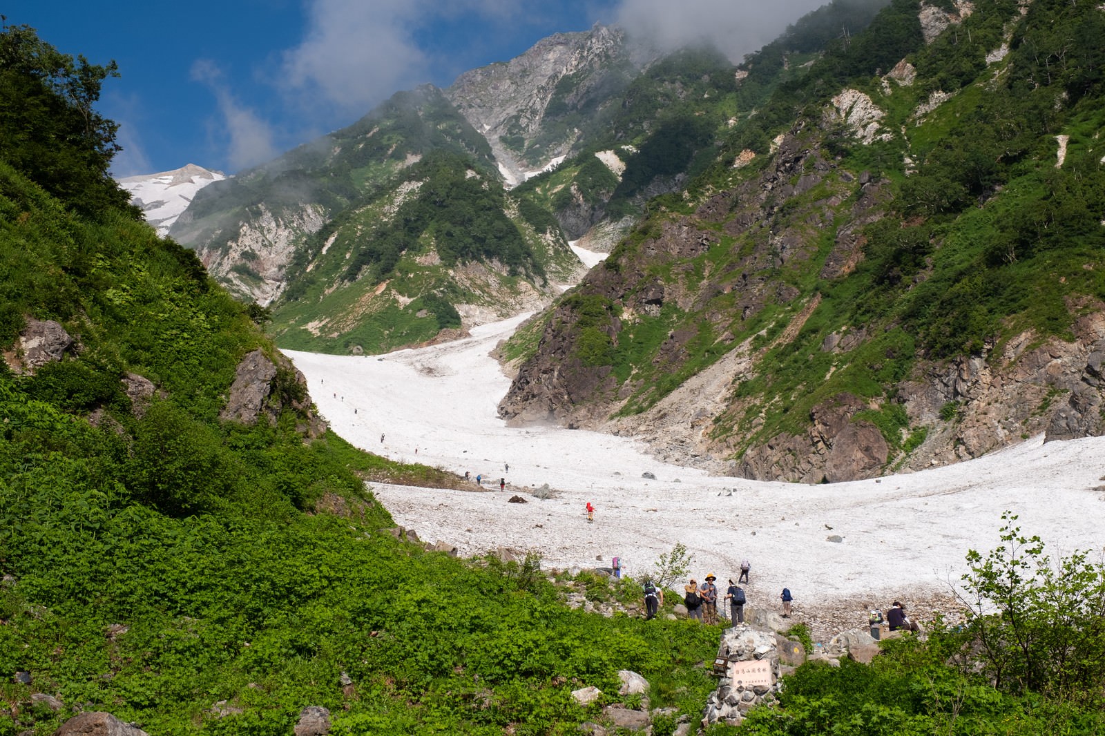 白馬大雪渓の登山ルート取り付き部分を歩く登山者たち