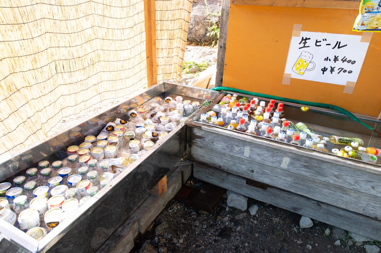 山小屋の木製水槽に浮かべて冷やされた缶ビールとドリンク類