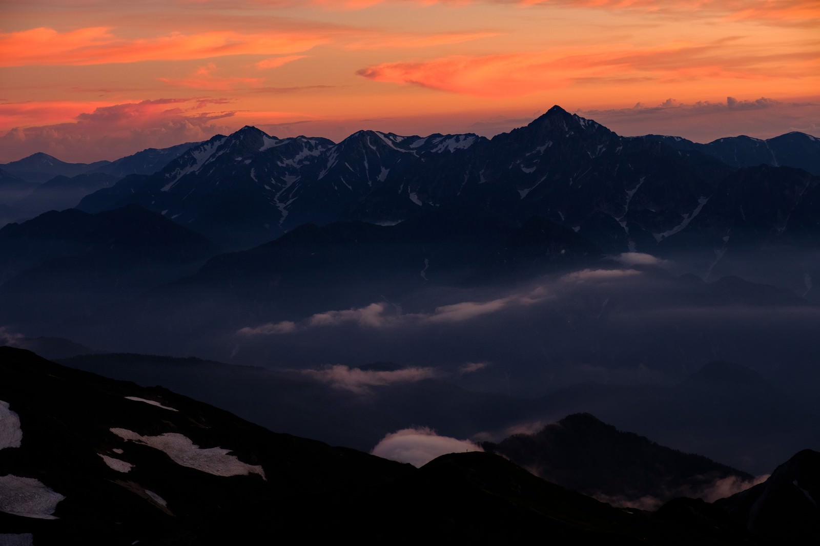 白馬岳から眺める夕焼けに染まった立山連峰のシルエット