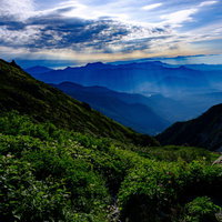白馬岳から望む雲間から伸びる光芒と後立山連峰の写真