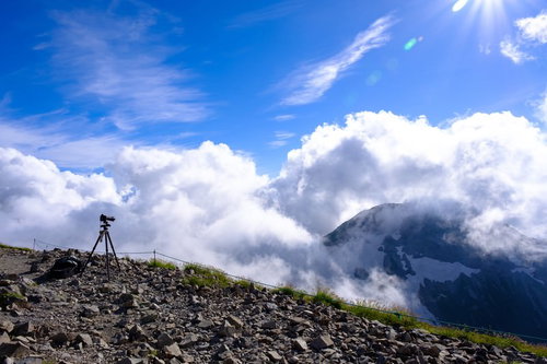 白馬岳山頂から眼下に見える雲と三脚を立てた登山者