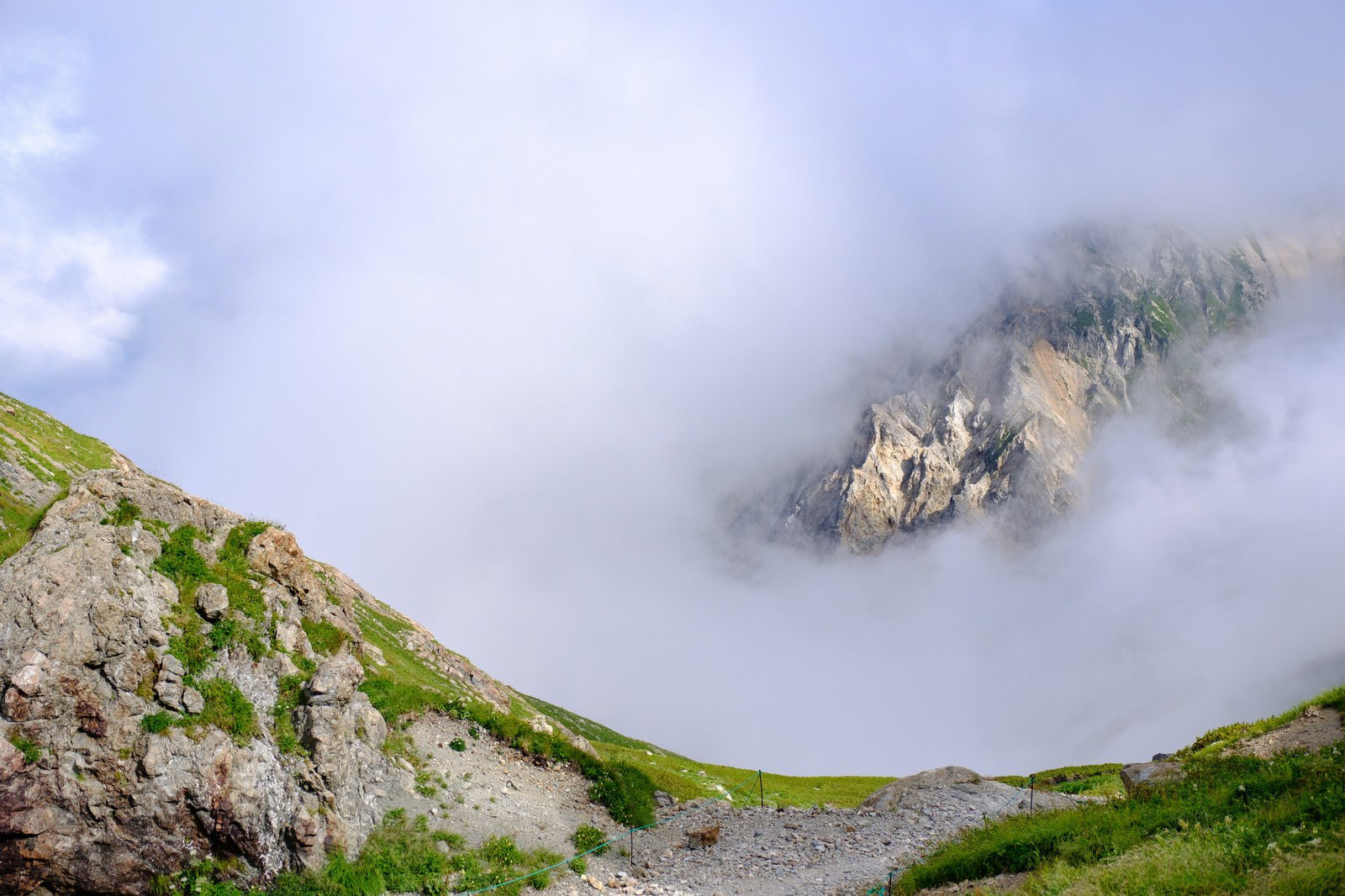 白馬岳山頂から見た雲海とガスに包まれた岩山の風景
