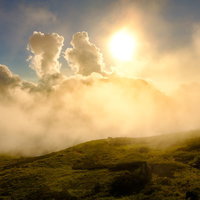 白馬岳稜線の沸き立つ雲の中の夕日と山々の光景の写真