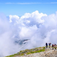 白馬岳の稜線を歩く登山者に迫る雲と雲海の風景の写真