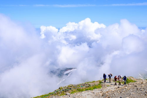 白馬岳の稜線を歩く登山者に迫る雲と雲海の風景
