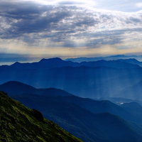 北アルプス・後立山連峰へ降り注ぐ光芒と山稜線の写真