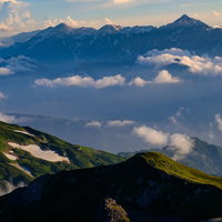 霞の向こうに見える立山連峰と剱岳、北アルプスの山々の写真