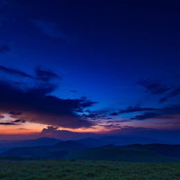 八島湿原の夕暮れ、深いブルーの空とオレンジ色の夕焼けの写真