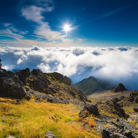 北アルプス3000m峰の山頂から見る黎明感ある空と雲海の写真