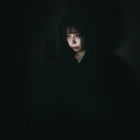 スマホ依存とストーカーに悩む女性の深刻な表情の写真