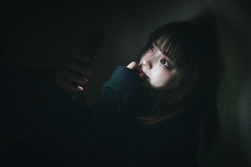 夜な夜なTikTokで時間が溶ける、スマホに没頭する女性