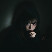 スマホを手放せない若い女性の憂鬱な日常とSNSトラブルの写真