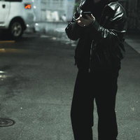 夜の街を夜回りする怪しい男性がスマートフォンを操作の写真