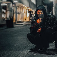 深夜、周囲を警戒しながら市街地を周る男性の様子の写真