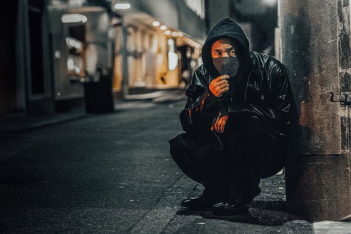 深夜、周囲を警戒しながら市街地を周る男性の様子