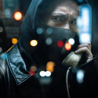 夜間に電話ボックスから怪しい指示を送る男性の写真