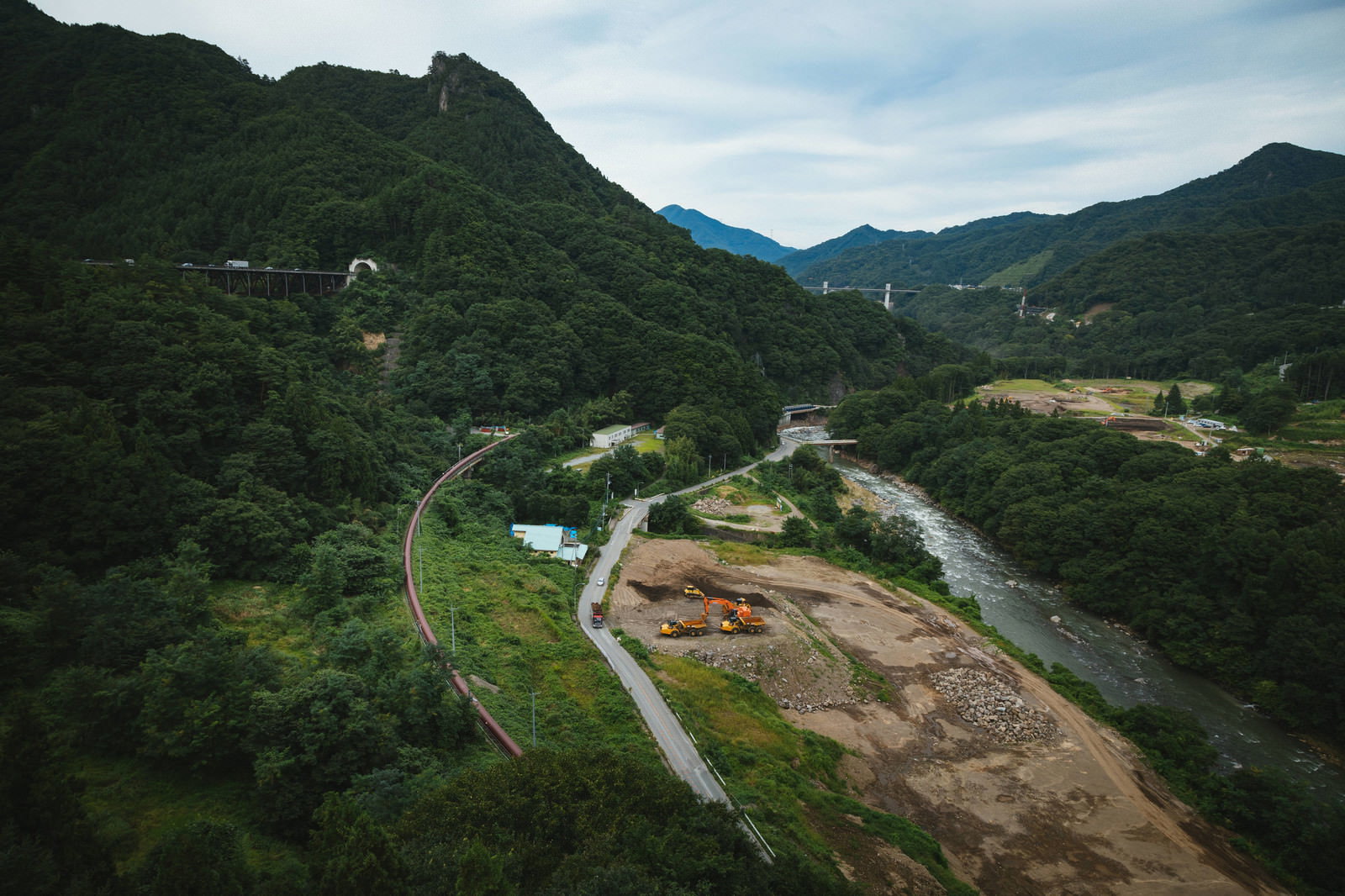 緑豊かな山間部で進められている八ッ場ダム建設工事現場の風景