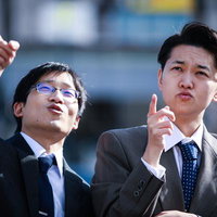 指さして上を確認するビジネスマン2人の写真
