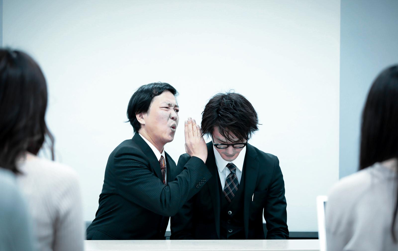 記者会見で質問する男性と応答する役員の写真［モデル：のせ 村田裕章］