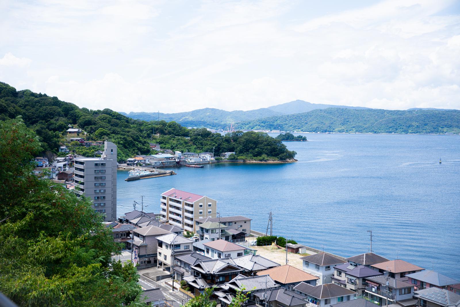 瀬戸内海に面した広島の港町。青い海に停泊する船と山々に囲まれた港湾の風景